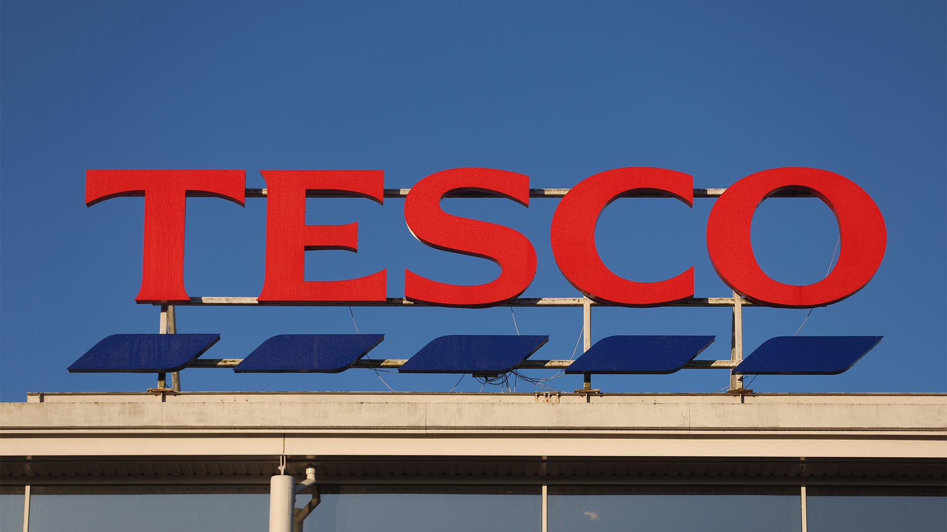 Tesco logo pictured on top of a supermarket branch in Altrincham, England. 