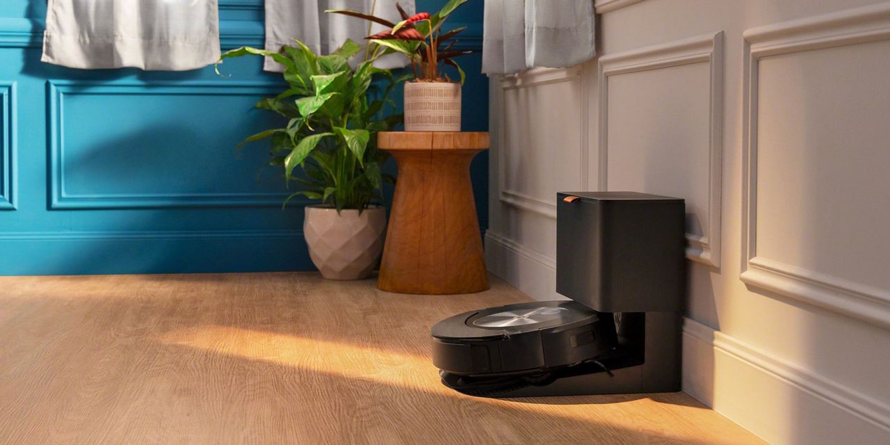 Robot vacuum cleaner by Roomba in room with wood floors