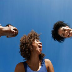 How to find joy: Three women smiling against a blue sky background