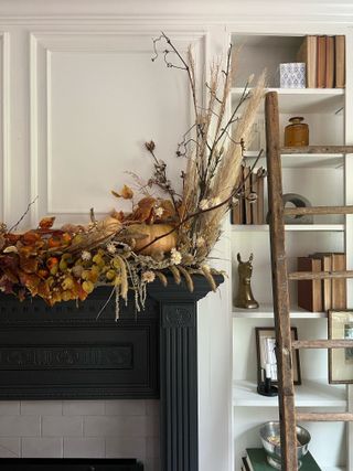 A mantel decorated with fall foliage