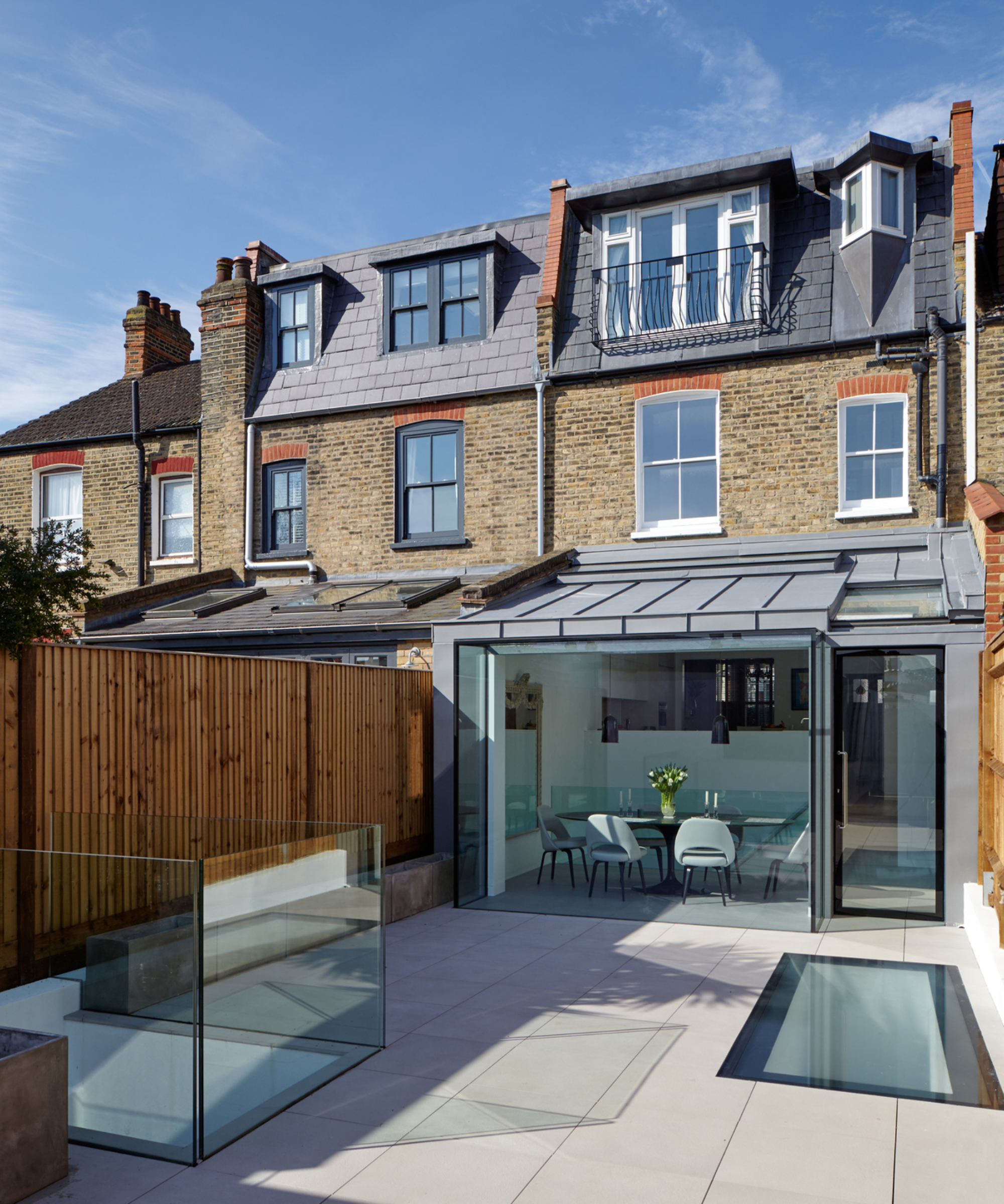 zinc clad single storey rear extension with glazed rear box elevation, glass floor planels and glass balustrade on section of patio