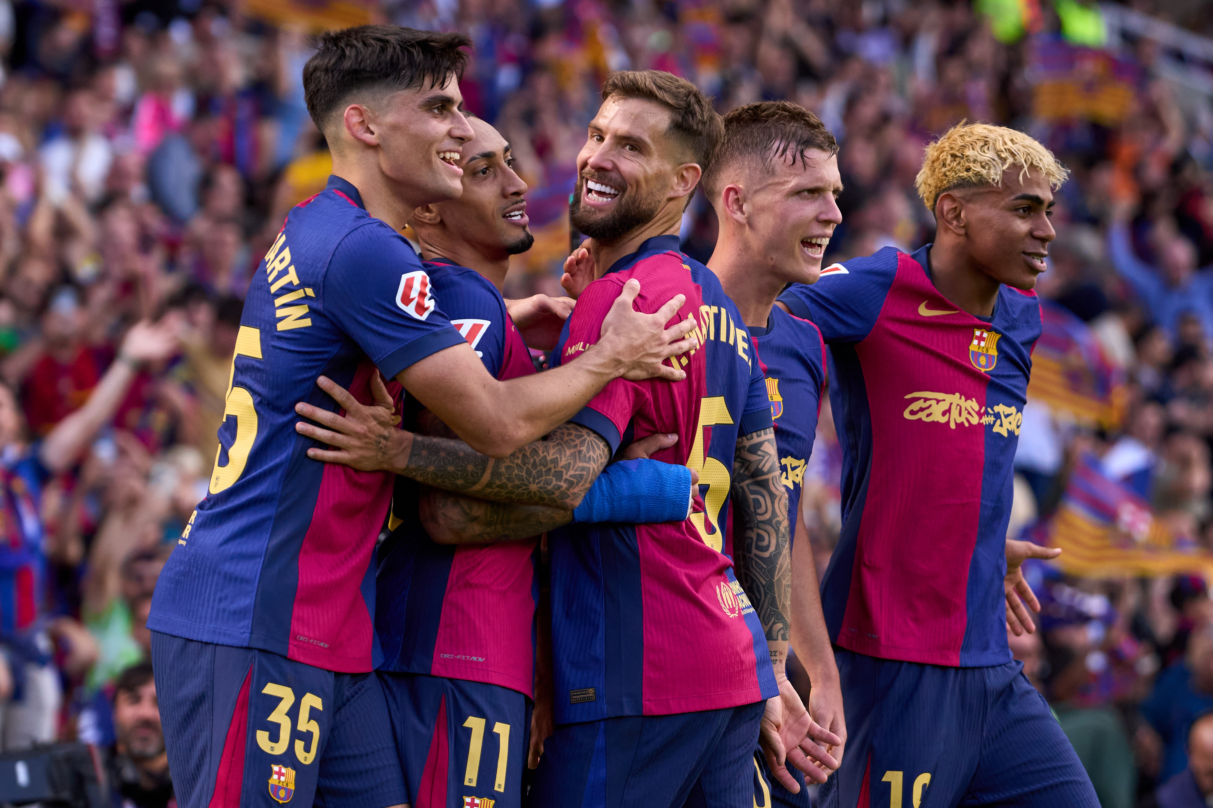Raphinha celebrates with his team-mates after scoring his second for Barcelona against Real Madrid in La Liga in May 2025.