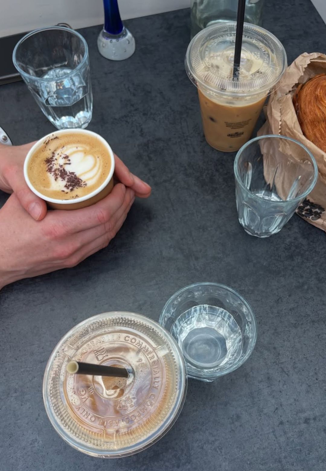 Three coffees and a pastry in a coffee shop