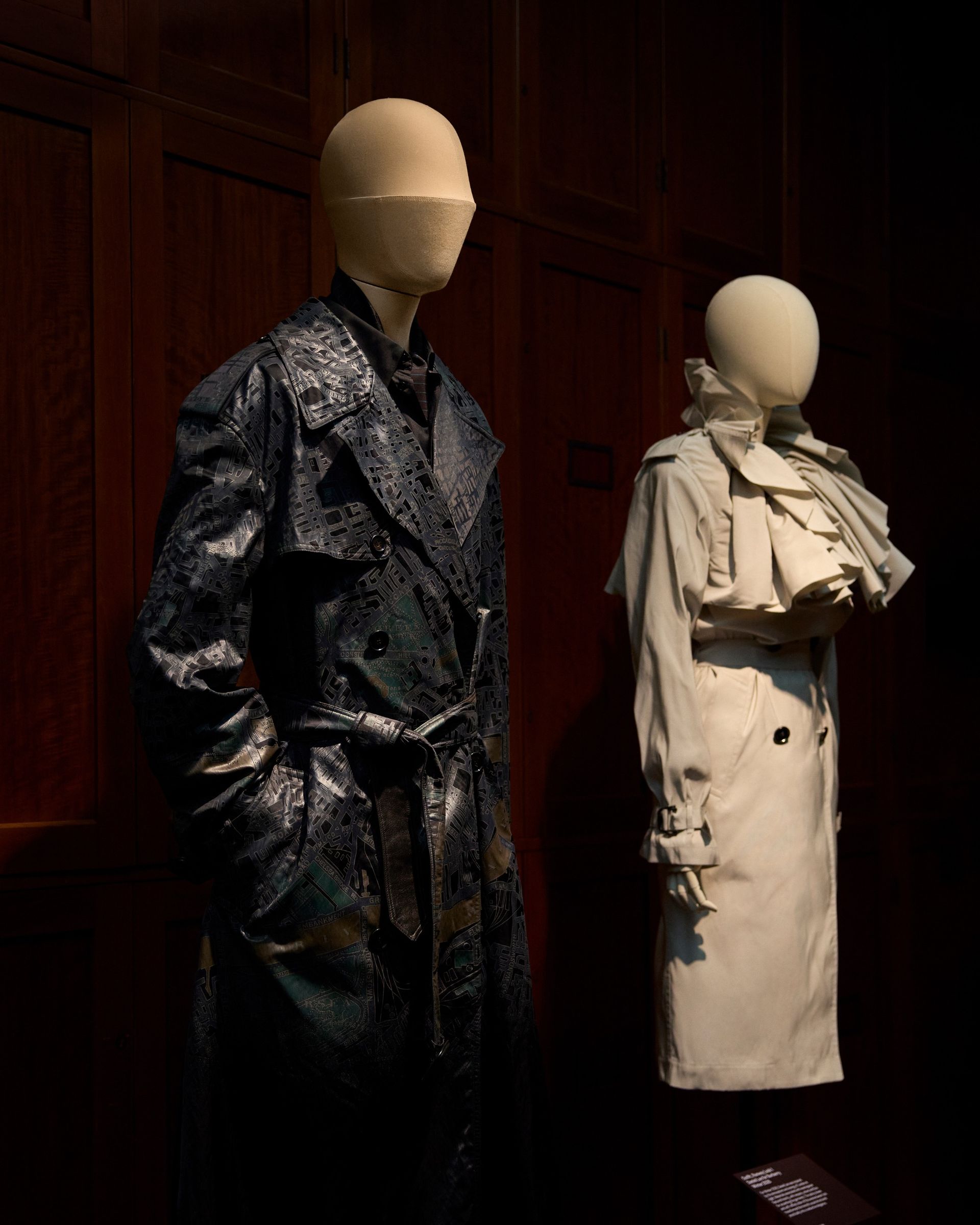A pair of trench coats on display at Burberry V&A exhibition