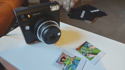 The Instax SQ40 with two images captured by it laying in front