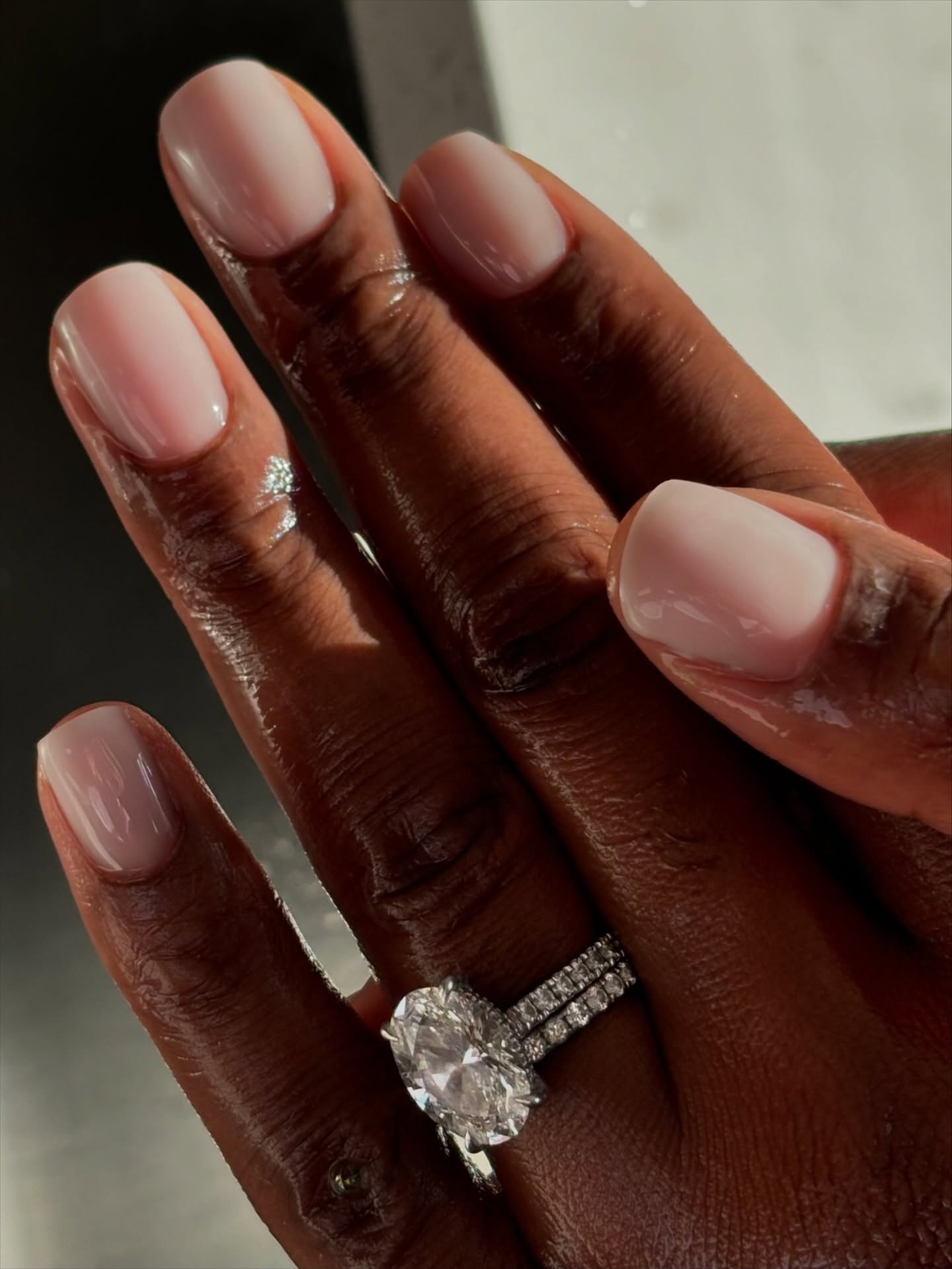 A close up of silk veil nails with a sheer white-pink polish