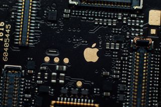 Image of a golden apple on the iphone se phone motherboard. Detached loopback connectors. Close-up, macro shot.