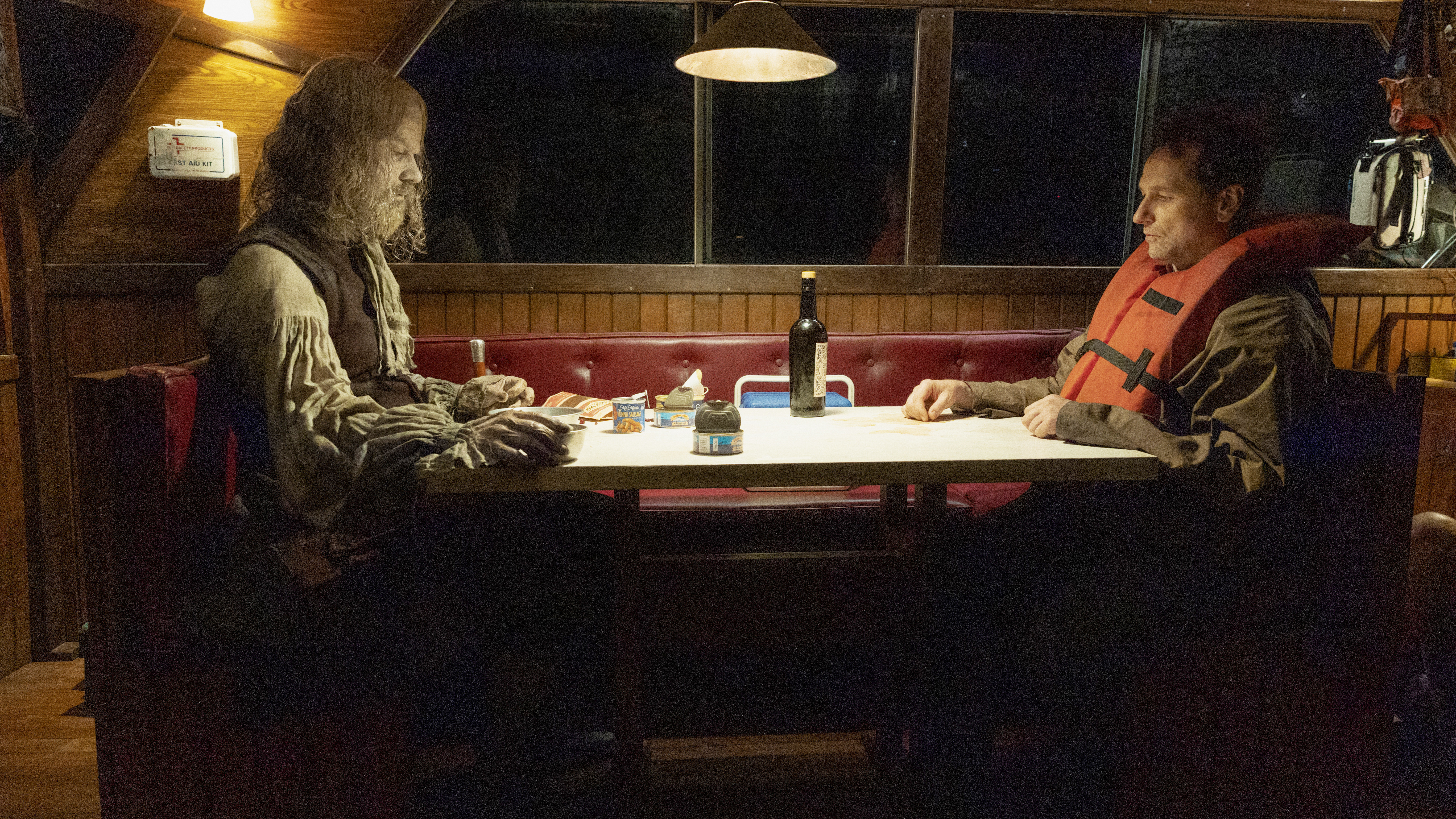 A zombified Richard Warren sitting across from Tom Loftis on a boat at night in Widow's Bay episode 7