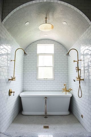 white tiled bathroom and shower room, bathtub, double gold showers