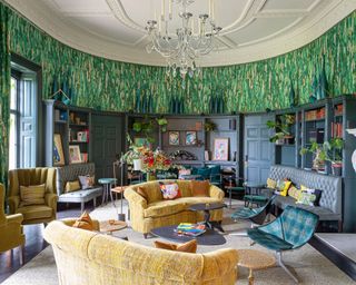 Traditional living room with yellow sofa and green fabric wall