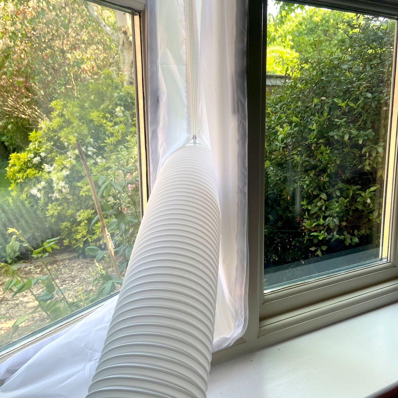 The MeacoCool MC Series 7000BTU Portable Air Conditioner being vented out of a window via the exhaust hose