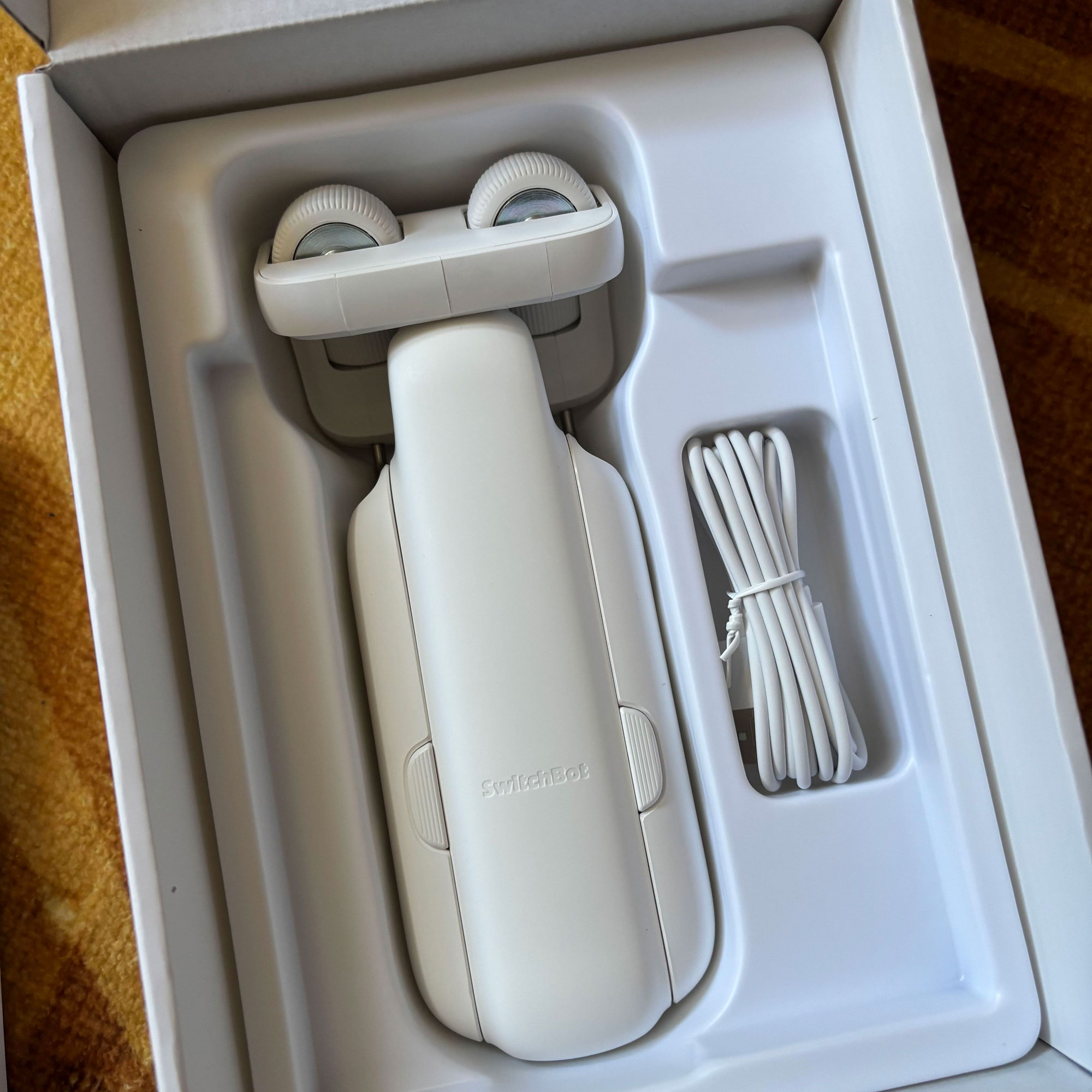 White curtain robot in a box with charger