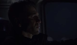 The Punisher sits in his car, scowling