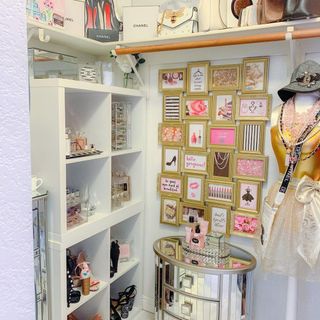 Feminine closet idea with pink accents and gallery wall of small, gold framed couture prints
