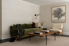 modern living room with beige walls and green velvet sofa