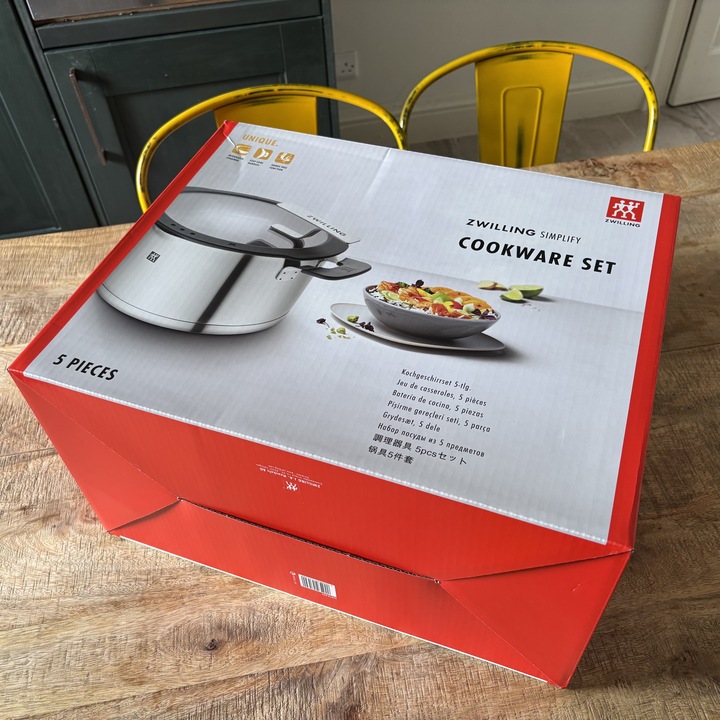 The box of the Zwilling Simplify Pot Set placed on a wooden kitchen table.