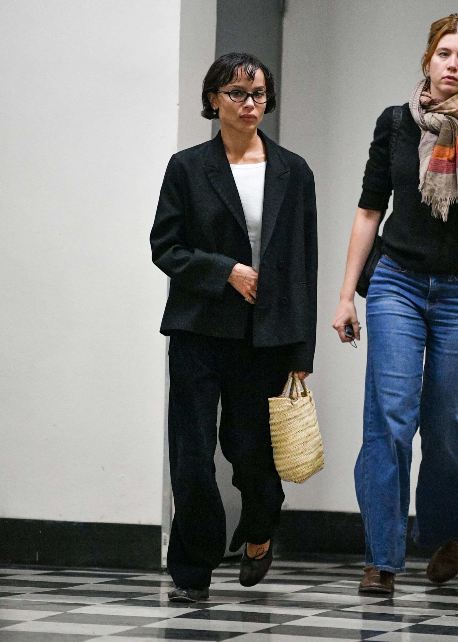 Zoë Kravitz leaving Sushi Park in West Hollywood with a friend, dressed in a sharp black blazer, relaxed trousers, and ballet flats. Her chic micro bob completes the look.