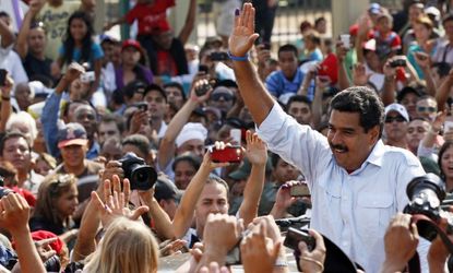 Maduro greets supporters as he leaves a polling station after voting in the presidential election in Caracas on April 14.