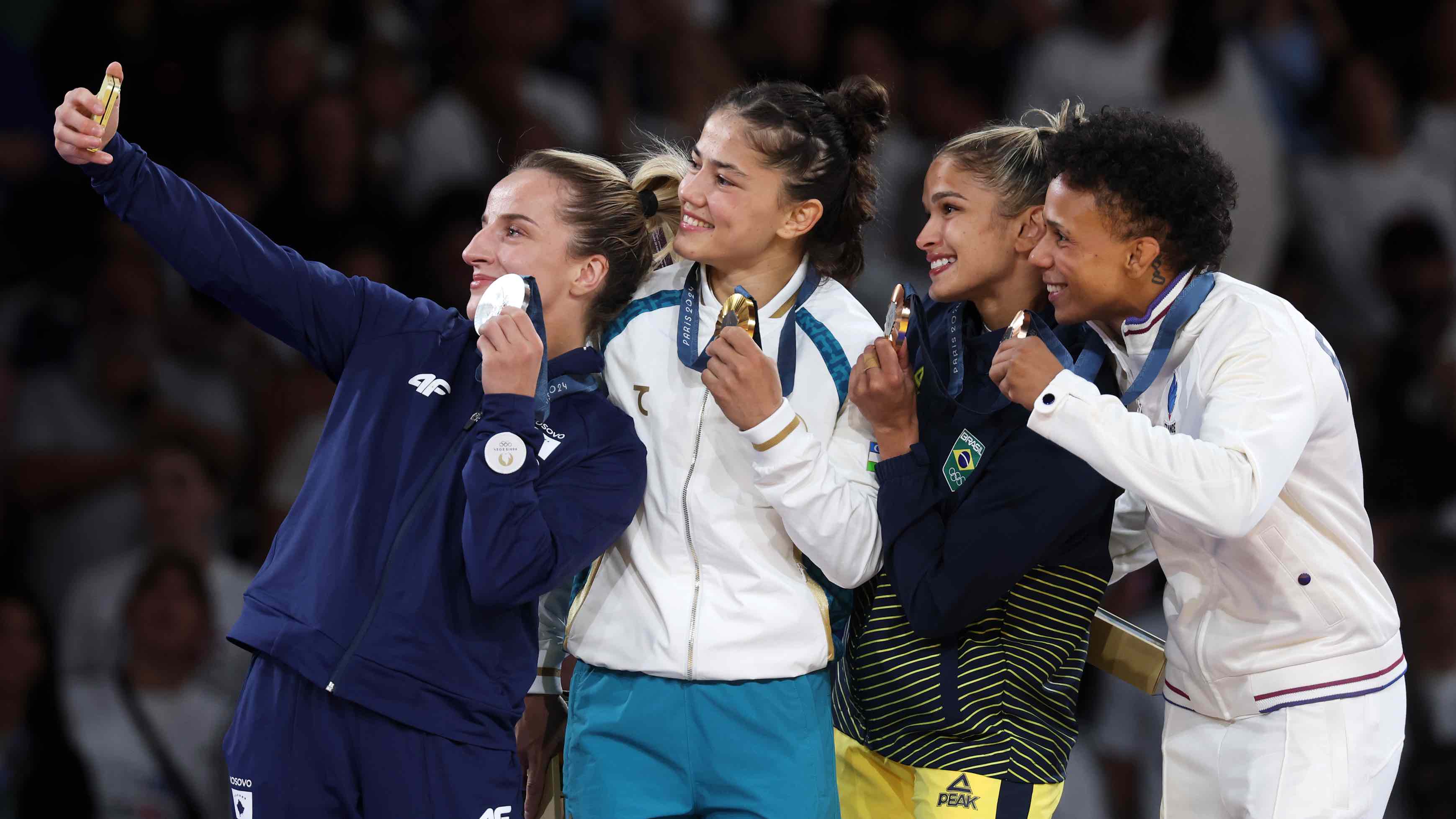 Gold medalist Diyora Keldiyorova of Team Uzbekistan (center), silver medalist Distria Krasniqi of Team Kosovo (left) and bronze medalists Amandine Buchard of Team France and Larissa Pimenta of Team Brazil (right) take a winner's selfie with the Samsung Galaxy Z Flip6 Olympic Edition on the podium during the women's -52kg tournament on the second day of the Paris 2024 Olympic Games at the Champs-de-Mars Arena on July 28, 2024 in France. (Photo by Michael Reaves/Getty Images)