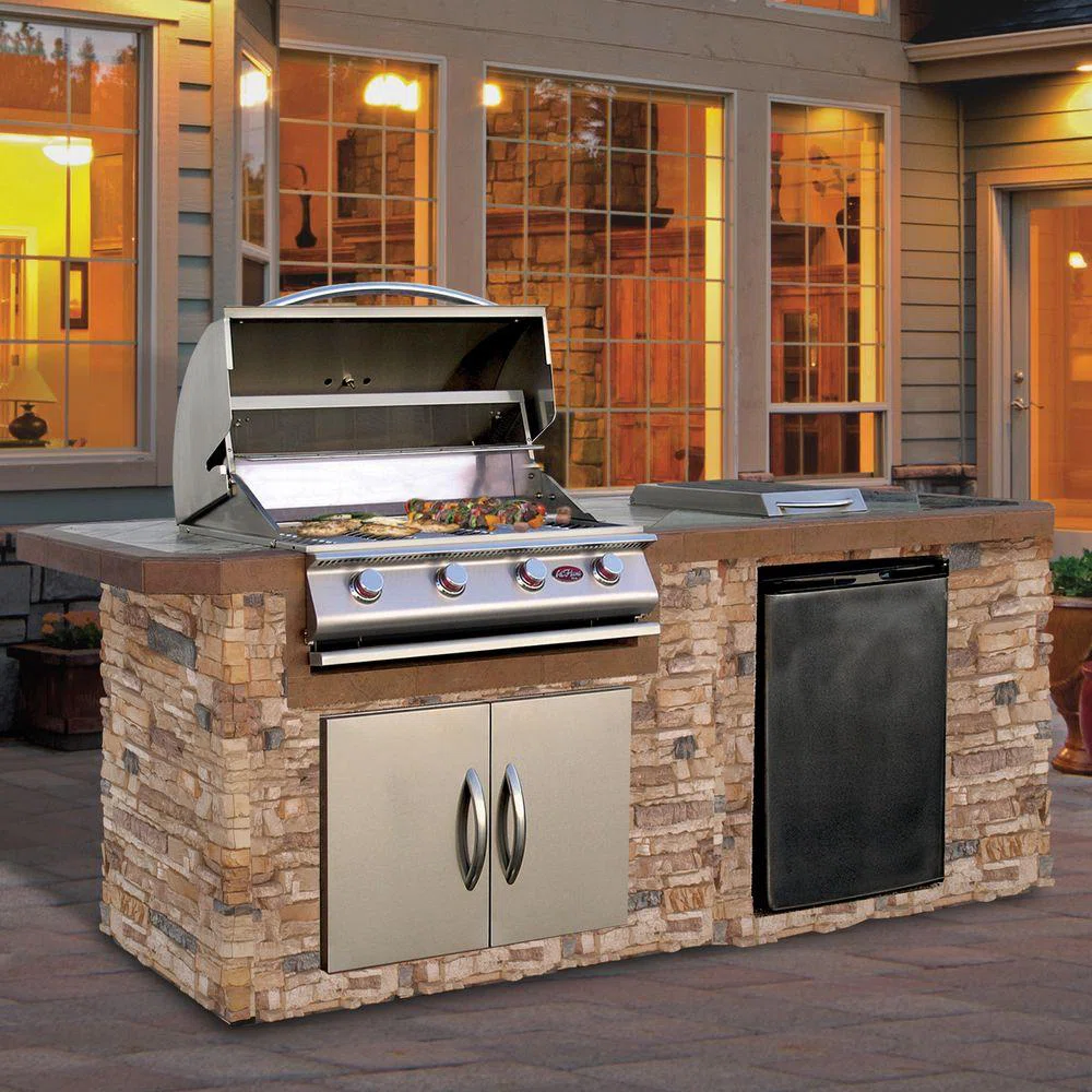 A stone grill island at dusk on a back patio