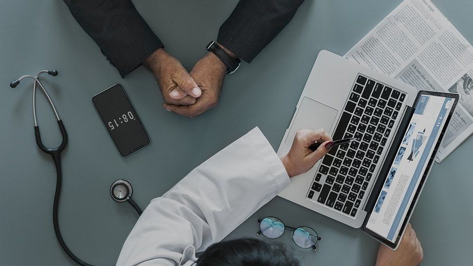 An image of a doctor showing a patient a medical record