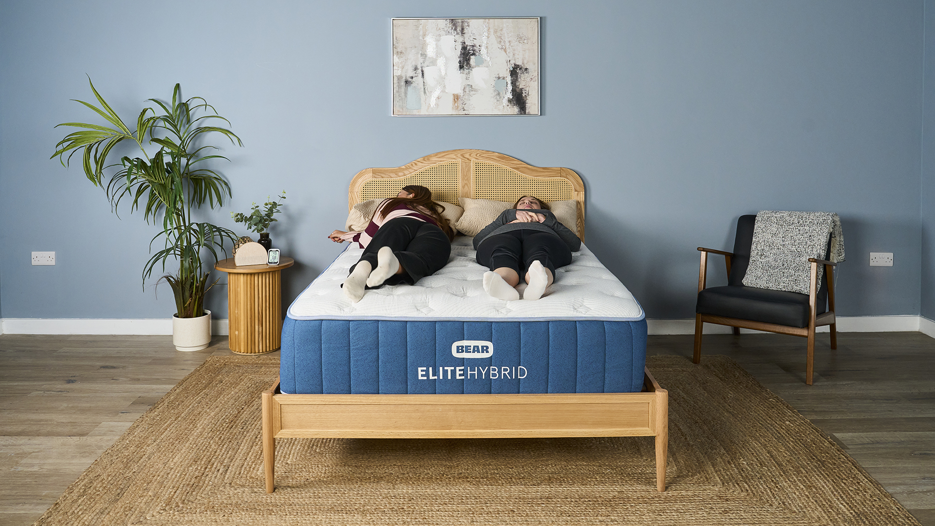 In this image we see two of our experts testing the comfort, support and motion isolation of the Bear Elite Hybrid Mattress in our sleep studio. Tester Eve Davies lies on the left of the mattress on her front. Tester Ruth Jones lies on the right of the mattress on her back.