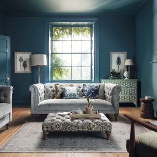 blue living room with grey sofa in front of window