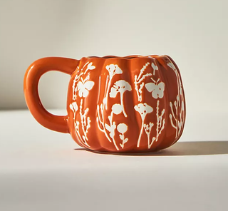 An orange floral pumpkin shaped mug 