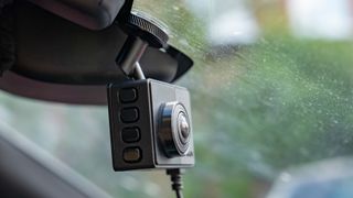 Garmin Dash Cam 67W mounted to the front windscreen on a cloudy day