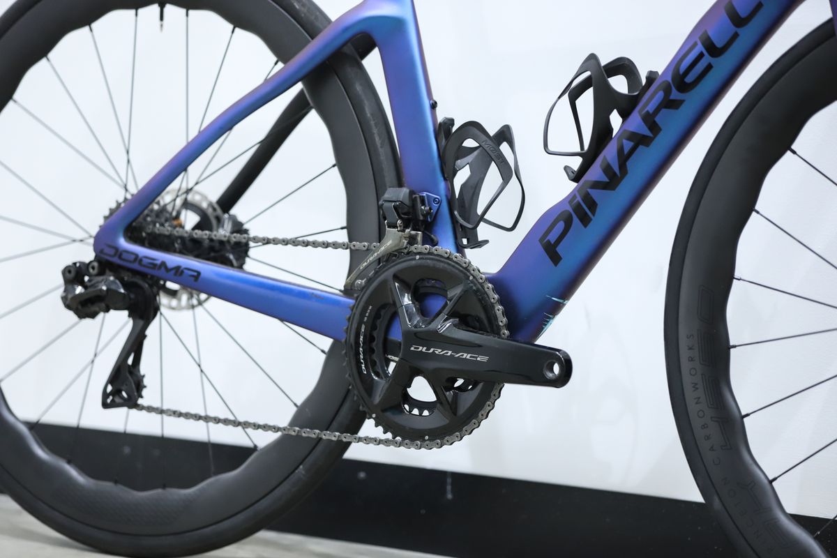 A blue pinarello dogma f stands against a white wall