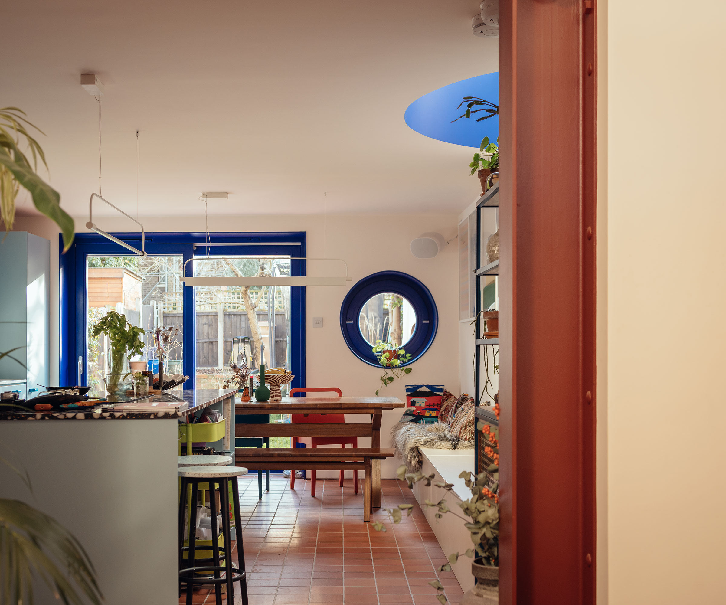 kitchen diner with blue circular window and blue sliding doors