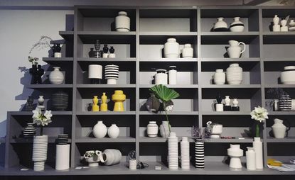 Wall-mounted storage racks topped with ceramic vases 