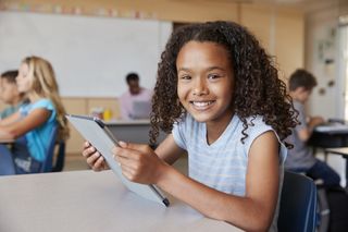 Young girl, smiling, with tablet. 