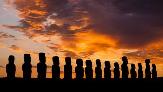 A view of the Easter Island sculptures silhouetted at sunset