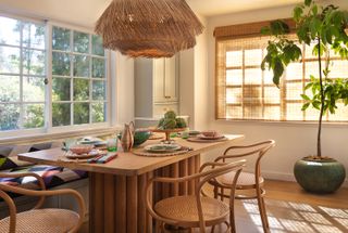 oak kitchen dining table with a window seat covered in patterned fabric