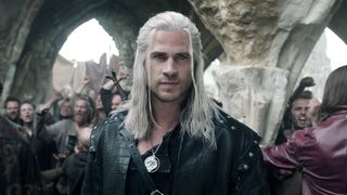 Geralt half-smirking in front of a rowdy crowed in The Witcher season 4