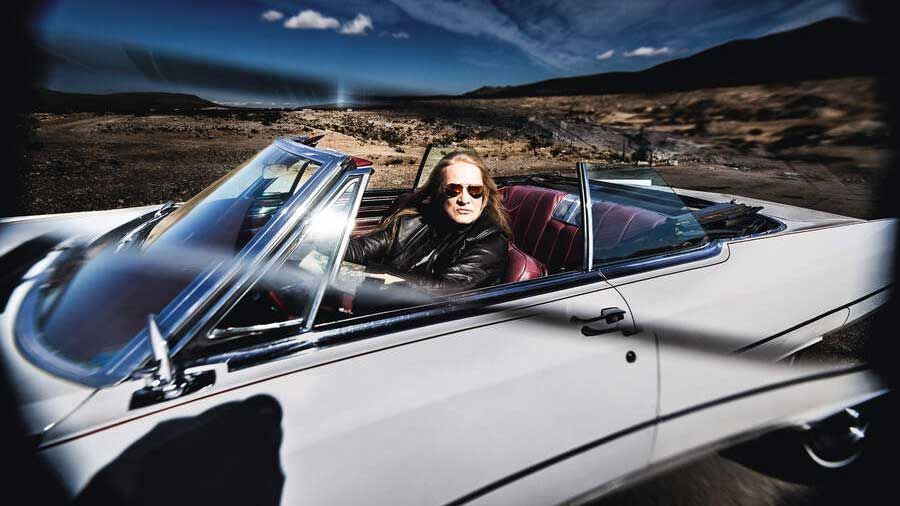 Sebastian Bach in a convertable car in the desert