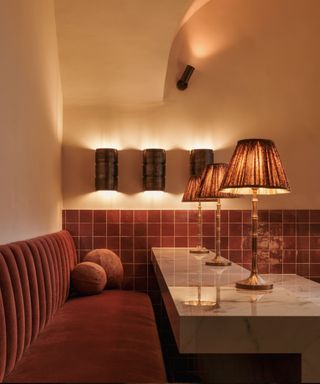 orange themed bar corner with tiled wall and small lamps