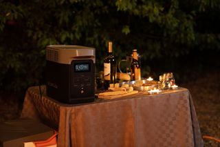 Portable power station in use on table top set for entertaining outside