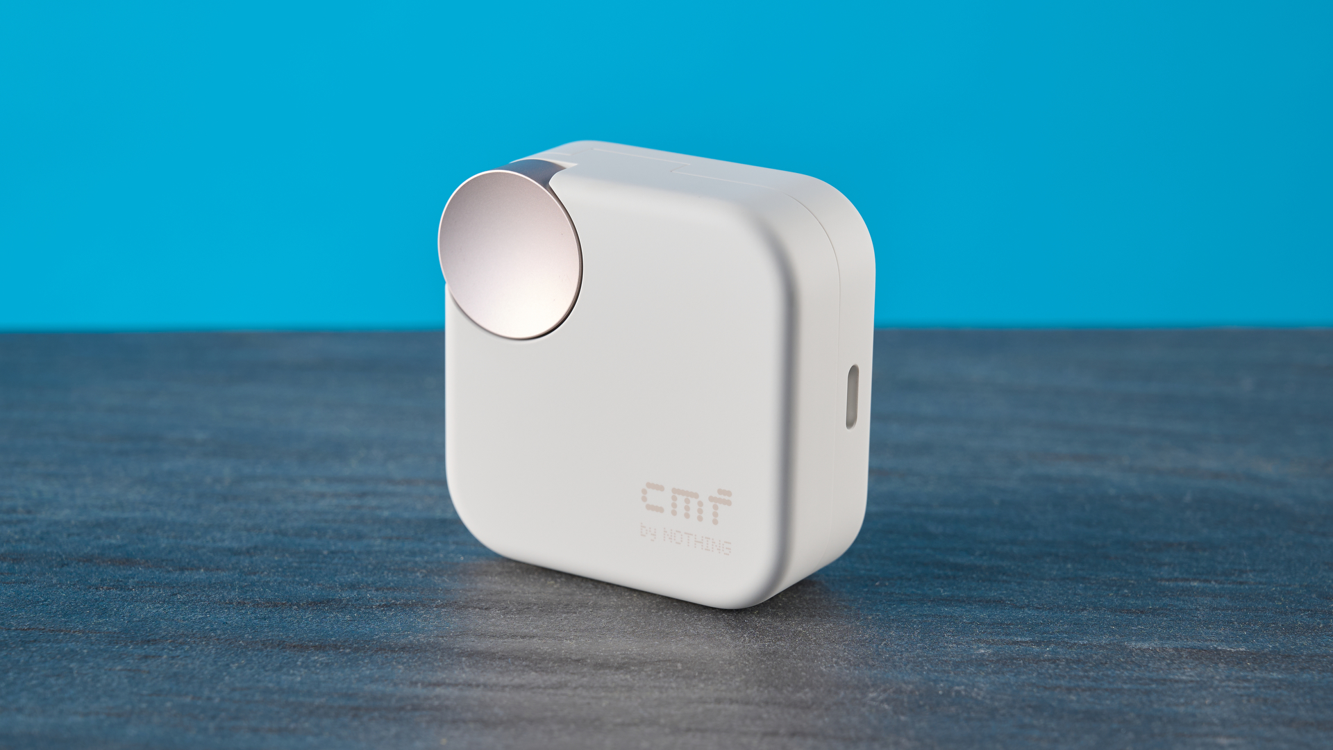 CMF Buds 2 Plus in light gray photographed in front of a blue background