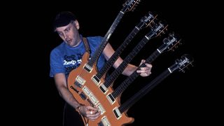 American musician Rick Nielsen plays a five-necked guitar with the band Cheap Trick during a performance onstage, Chicago, Illinois, June 15, 1990. 