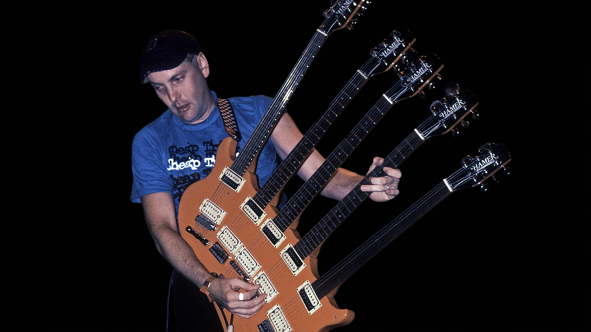 American musician Rick Nielsen plays a five-necked guitar with the band Cheap Trick during a performance onstage, Chicago, Illinois, June 15, 1990. 