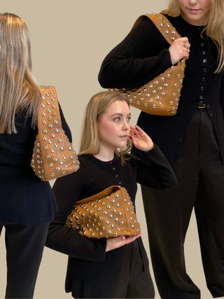 Woman wears black top and carries brown studded bag