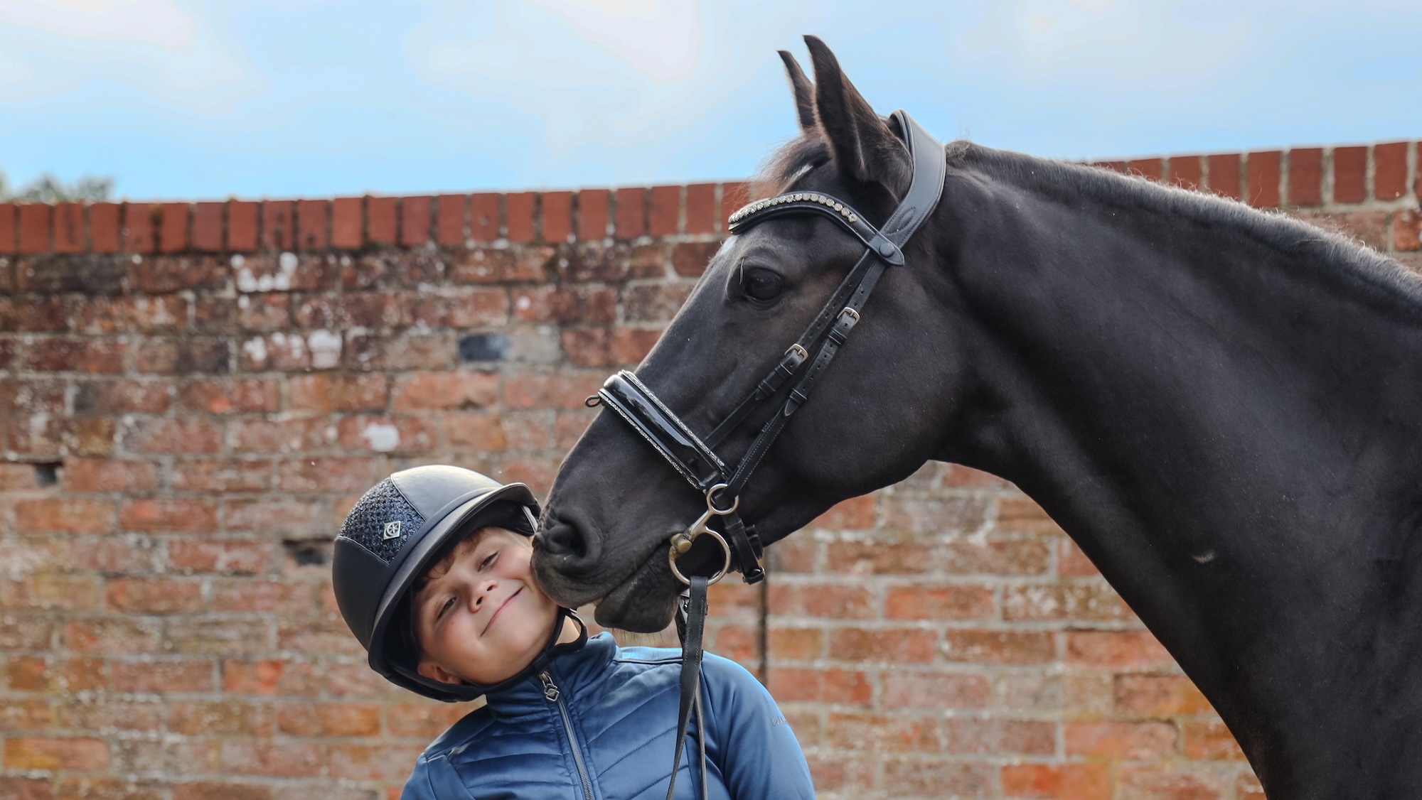 Young rider Dylan Ward kissing his bay pony