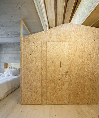 The third floor contains the house's bedrooms and bathrooms - the latter enclosed in a house-shaped explosed wood construction
