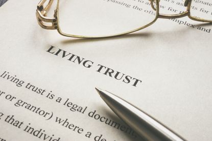 Living trust document with a pair of glasses and a pen resting on top of it.