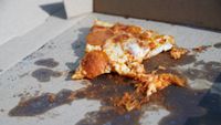 Pizza slice on cardboard
