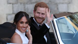 Meghan Markle and Prince Harry wave to the crowd from their car on their wedding day.