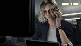 Screenshot of Resident Evil Requiem cutscene with Grace Ashcroft at desk while on phone and DLSS 5 on badge in top right corner with red cross over.