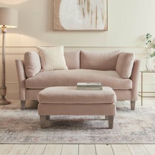 Cox & Cox Dinan Two Seater Sofa & Ottoman in a cream-painted living room with a floor lamp and vintage-style rug